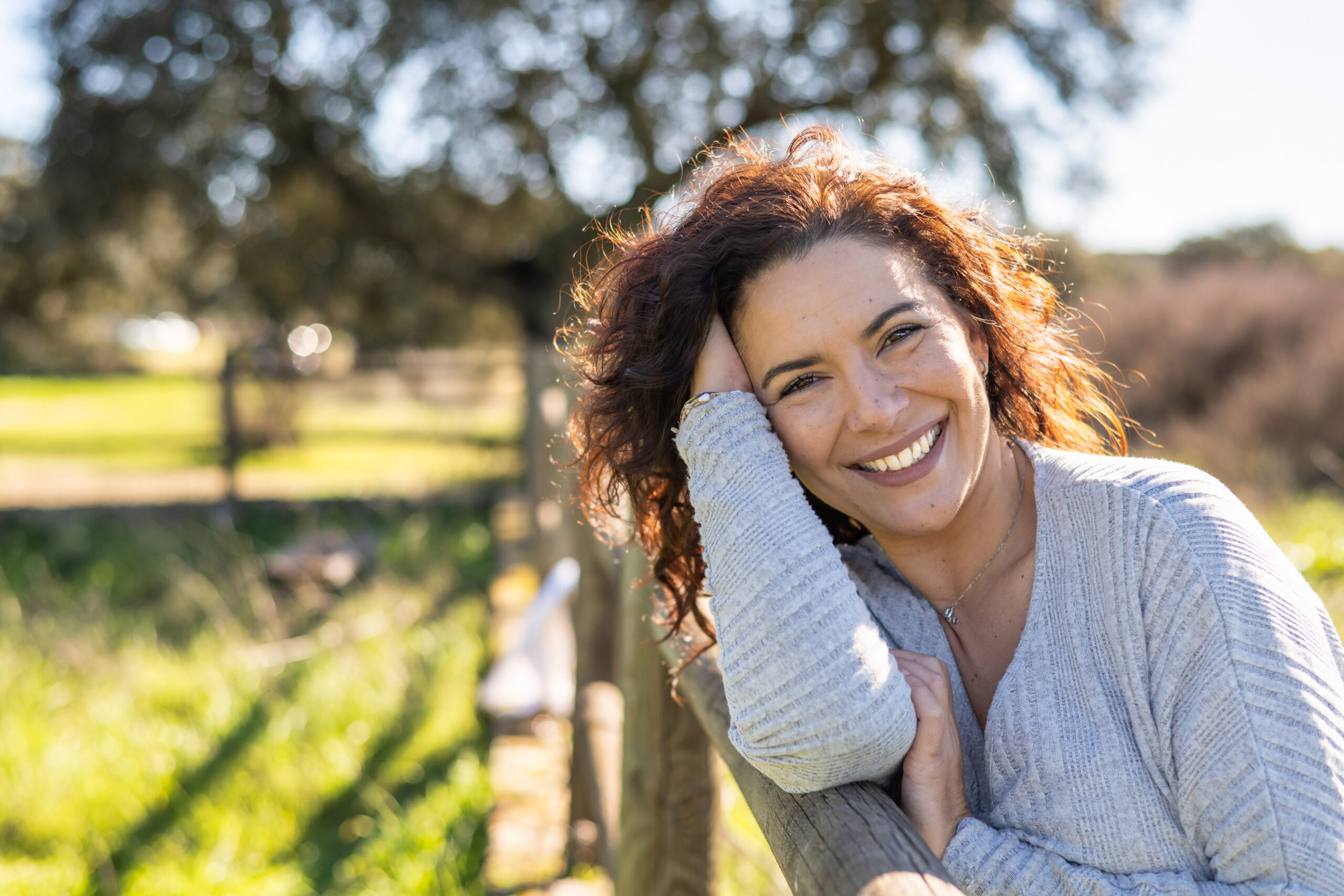 Attractive Woman Looking At Camera And Smiling With Positive Emotion. Nature Background