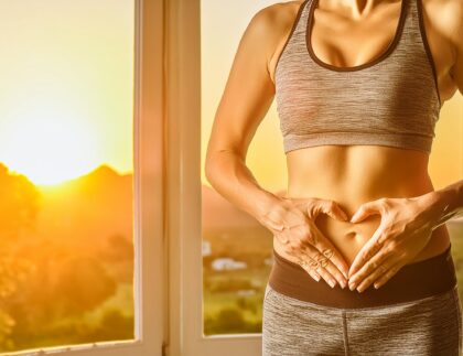 Gut Health picture, with a women with gym suite showing heart shape in her stomach